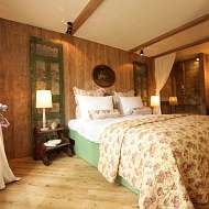 großes Doppelbett mit Blick in den großen Garten