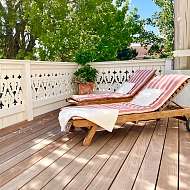 Sonnenterrasse der Guten Stube mit Sonnenliegen und Essbereich