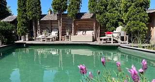 Naturpool mit Sonnenbetten und Liegen